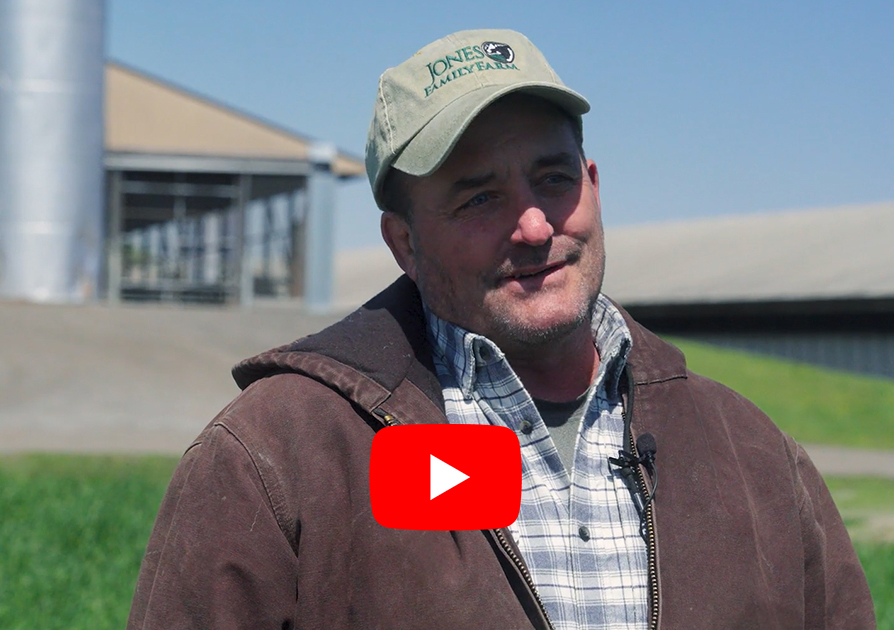 Farmer standing in front of dairy barn and cover crop field - Links to YouTube Video on cover crops 
